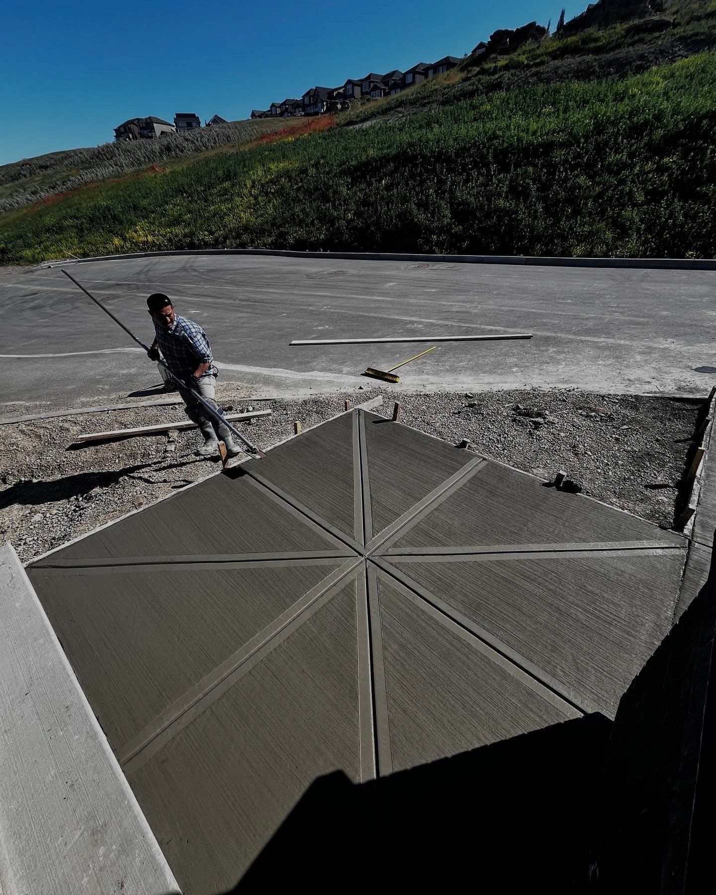 Star-patterned concrete finish with broom texture on a sloped driveway in Calgary